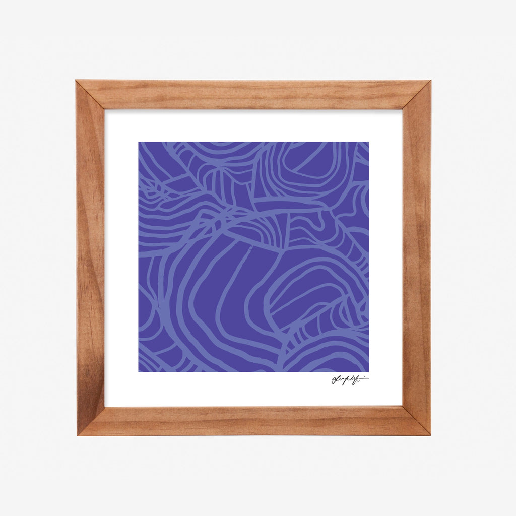 Framed artwork with a blue First Nations design inside a wooden frame on a white mount