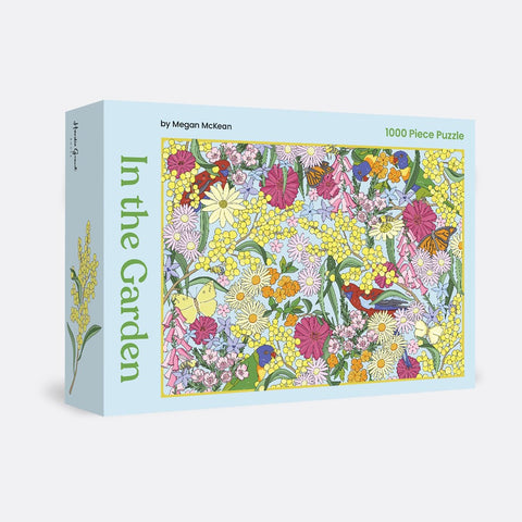 A 1000-piece jigsaw puzzle box with a vibrant floral and bird illustration by Megan McKean.
