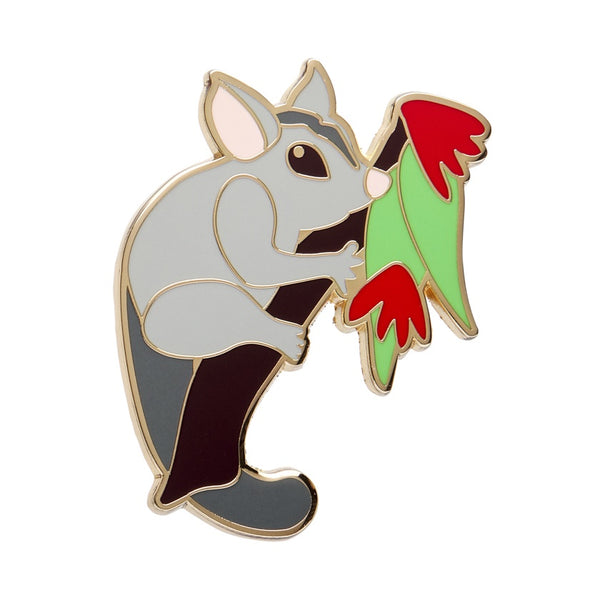 Enamel pin of a grey possum holding a leaf on a white background