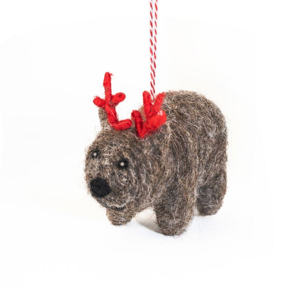 Felted wool wombat Christmas ornament with red antlers on a white background
