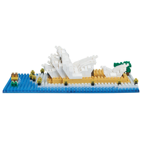 A completed nanoblock model of the Sydney Opera House with a blue base, white and beige details.