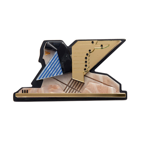 A brooch designed in the shape of the Great Sphinx with a human head and a lion's body, featuring gold, black, and blue colors with hand-painted details.