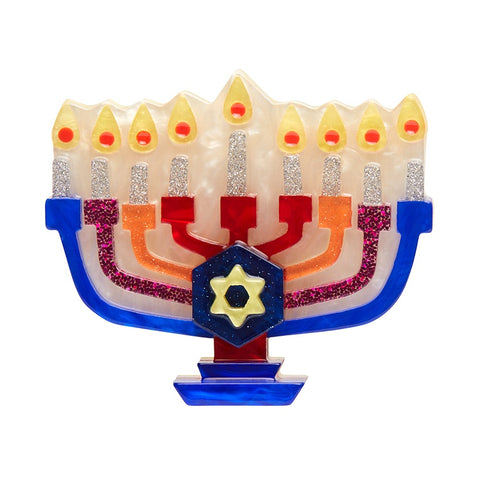 Erstwilder Holiday Lamp Brooch featuring a menorah in blue, pink, orange and red with silver glittery candles and a Star of David in the centre.