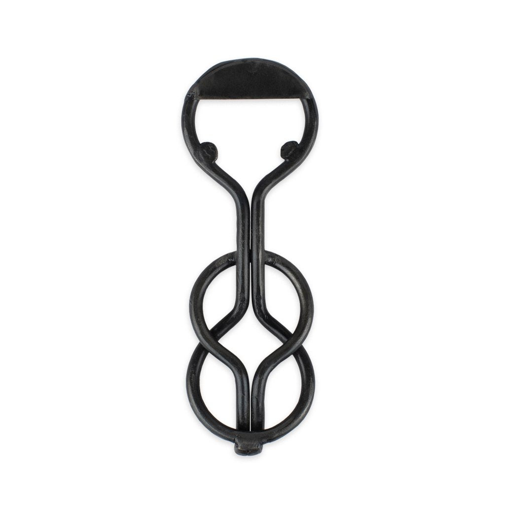 A blackened iron bottle opener with a unique, loop-shaped design.