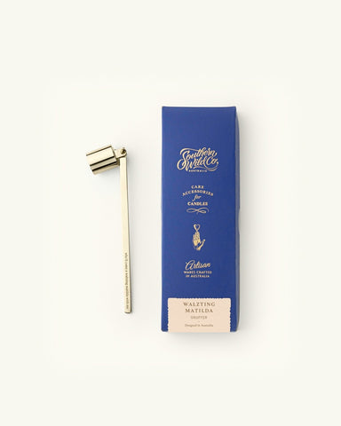 Gold plated candle snuffer placed next to its stylish blue gift box.