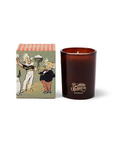 A small candle with amber glass and a kraft box packaging featuring an illustration of 'The Magic Pudding' by Norman Lindsay.