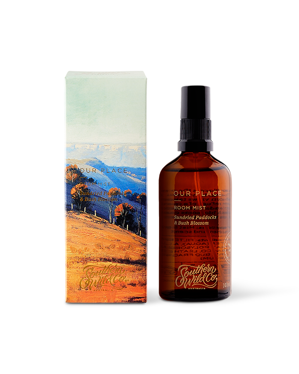 A scented room mist product by Southern Wild Co, featuring a brown amber glass bottle with a pump dispenser, and packaged in a box with a scenic artwork.