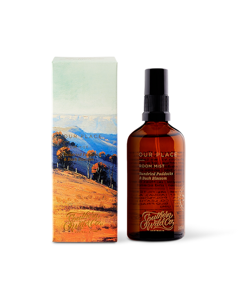 A scented room mist product by Southern Wild Co, featuring a brown amber glass bottle with a pump dispenser, and packaged in a box with a scenic artwork.