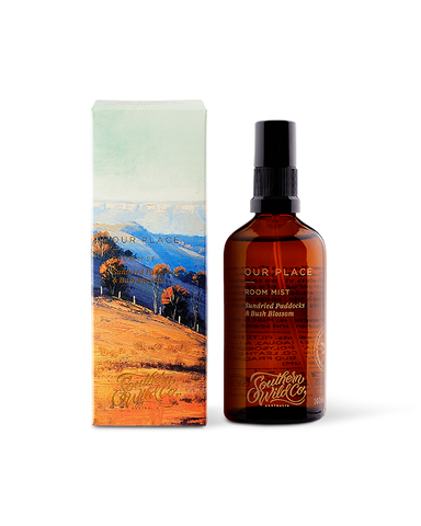 A scented room mist product by Southern Wild Co, featuring a brown amber glass bottle with a pump dispenser, and packaged in a box with a scenic artwork.