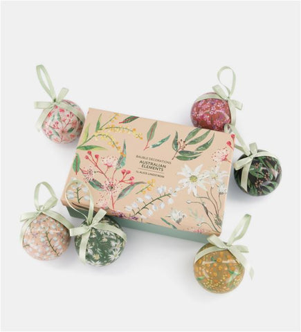 Decorative box with floral design surrounded by decorative balls on a white background