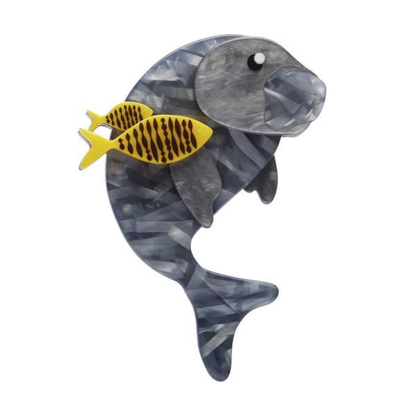 An Erstwilder brooch depicting a grey dugong with yellow and black fish on its back, made from layered resin.