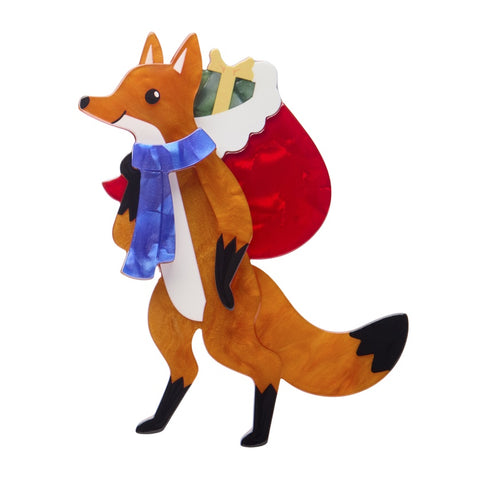 Erstwilder Freddy the Fox layered resin brooch features a fox standing upright with a blue scarf and carrying a Santa's sack full of gifts.