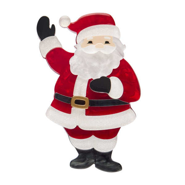 Erstwilder Santa’s Surprise layered resin brooch features a jolly Santa with one hand raised in the air.
