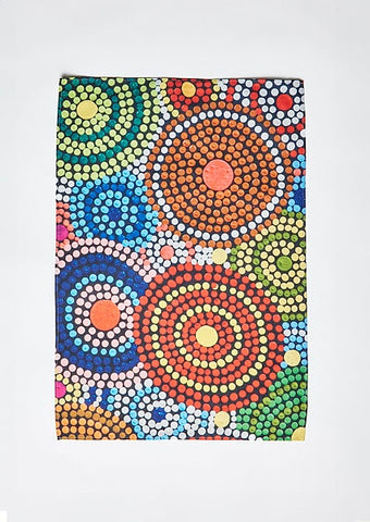A colorful tea towel featuring artwork by Coomaditchie artists Lorraine Brown & Narelle Thomas in a variety of bright colors
