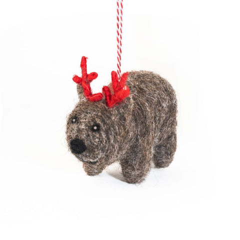 Felted wool wombat Christmas ornament with red antlers on a white background