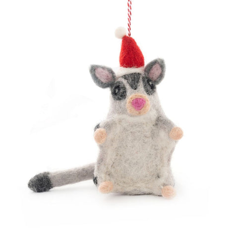 Felted animal sugar glider Christmas ornament wearing a red Santa hat on a white background
