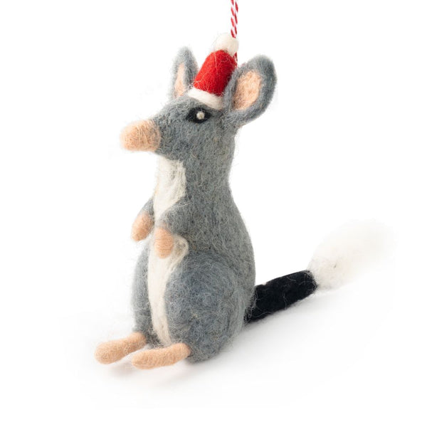 A felted bilby Christmas ornament wearing a Santa hat, hanging from a red and white string against a white background.