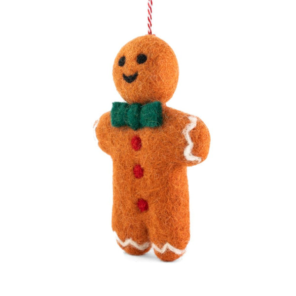 A felt gingerbread man ornament, with a green felt bow tie, red felt buttons, white felt trim, hanging from a red-and-white string, shown on a plain white background.