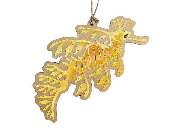 Decorative seahorse wooden ornament with yellow and brown pattern on a white background