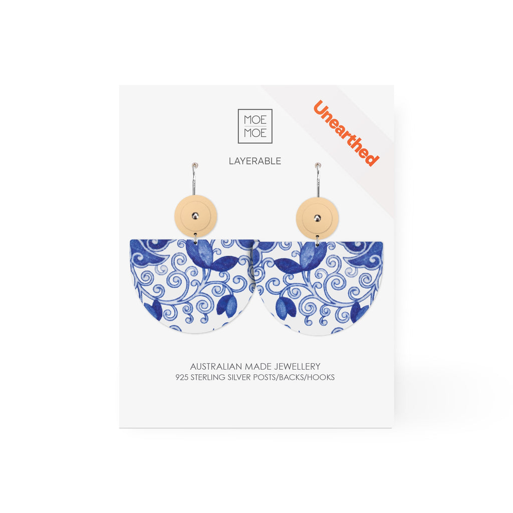 A pair of earrings featuring a blue and white pattern