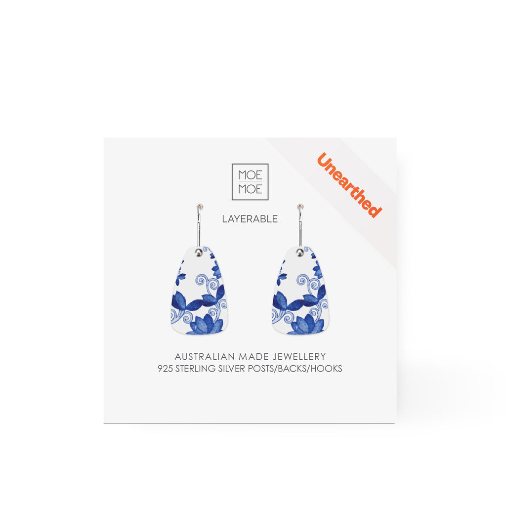 A pair of earrings featuring a blue and white pattern