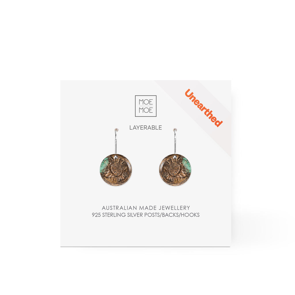 A pair of small circular drop earrings featuring a pattern created from a digital image from the archaeology collection at Museum of Sydney