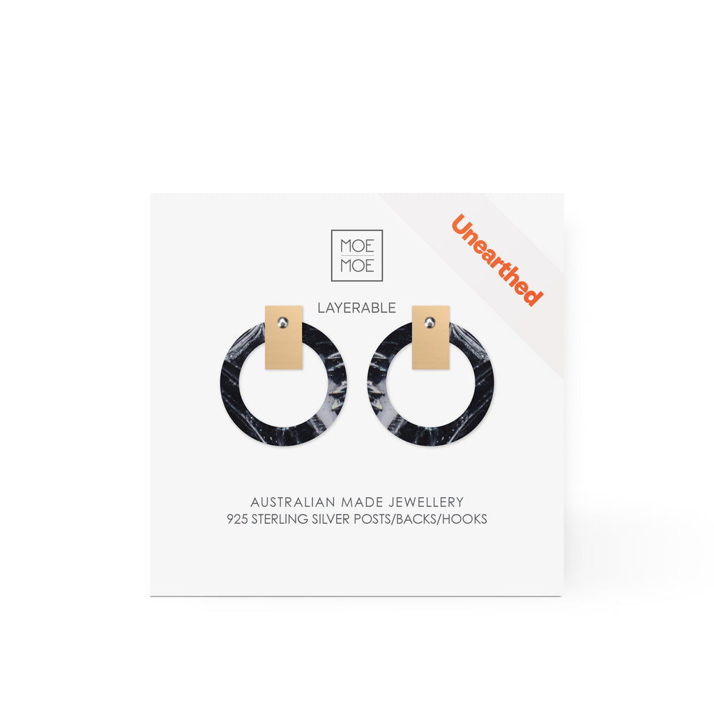 A pair of earrings featuring a black and white abstract pattern.