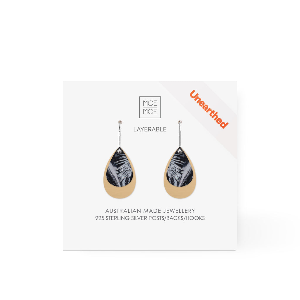 A pair of layered tear drop earrings featuring a black and white abstract pattern.