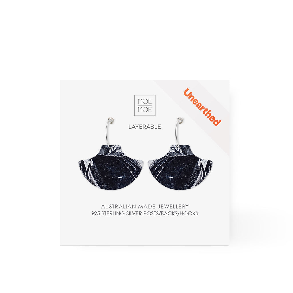A pair of earrings featuring a black and white abstract pattern.