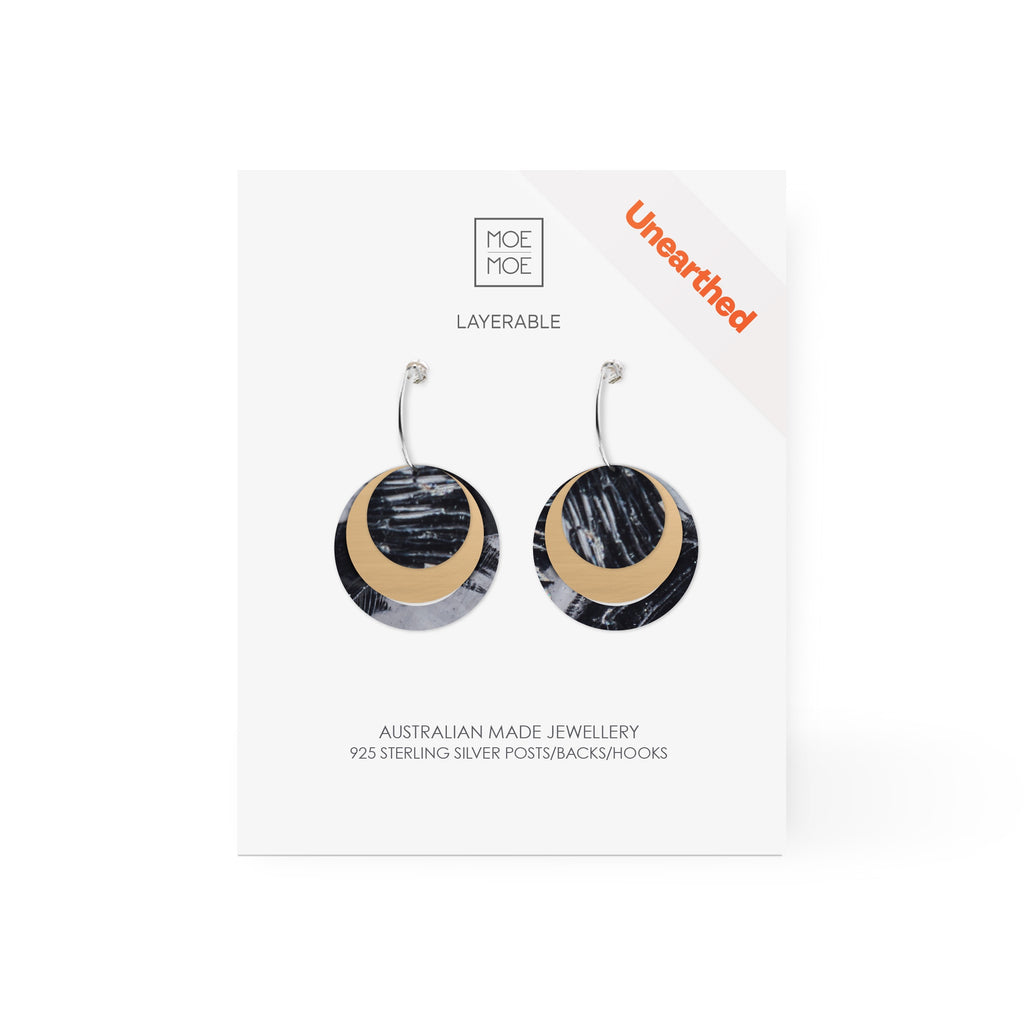 A pair of layered circular earrings featuring a black and white abstract pattern.