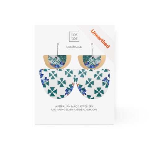 A pair of earrings featuring a green and white pattern