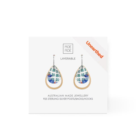 A pair of tear drop earrings featuring a green and white pattern