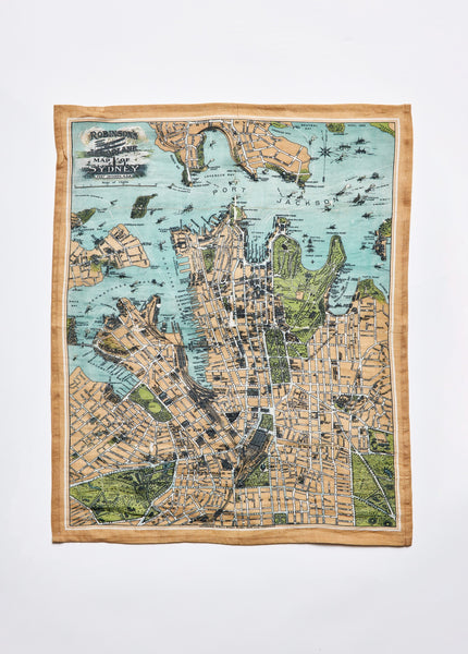 A linen and cotton tea towel with a vintage map of Sydney printed on it, featuring various streets and landmarks.