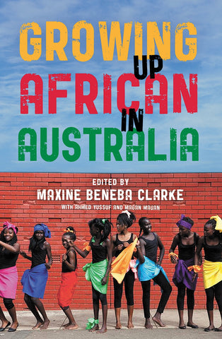 Cover of the book 'Growing Up African in Australia' featuring a group of young people standing in front of a red brick wall, expressing joy and togetherness.