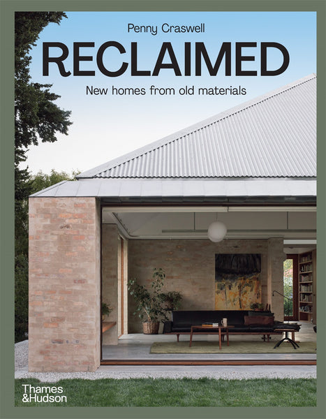 The cover of the book 'Reclaimed: New homes from old materials' by Penny Craswell, featuring a modern house with a visible brick wall and large windows, indicating a stylish home built with recycled materials.