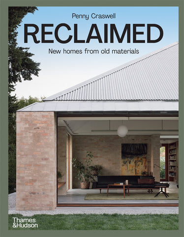 The cover of the book 'Reclaimed: New homes from old materials' by Penny Craswell, featuring a modern house with a visible brick wall and large windows, indicating a stylish home built with recycled materials.