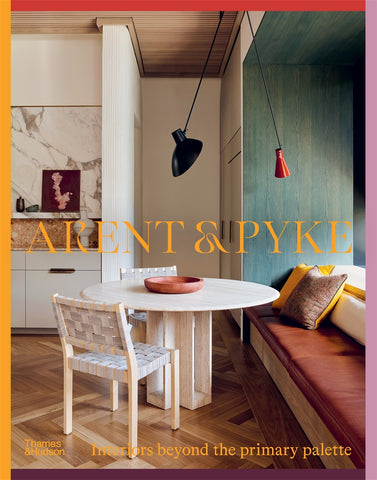 The cover of the book 'Arent & Pyke: Interiors Beyond the Primary Palette' featuring an interior design of a room with a round table, chairs, and a hanging lamp, with a color palette that includes white, beige, and blue tones.