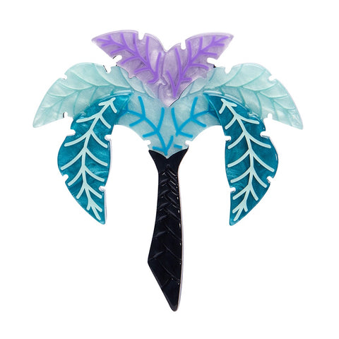 A layered resin brooch by Erstwilder in the shape of a palm tree with a vibrant blue and purple leaf design, and a black trunk.