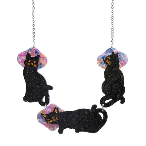 A black cat-shaped necklace by Erstwilder with glittery resin details, hanging from a silver-plated steel chain.