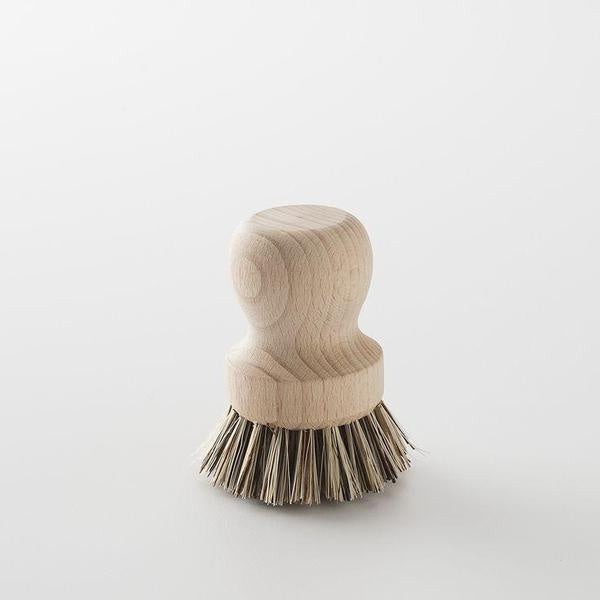 A beechwood pot and pan brush with natural bristles and a cylindrical shape, displayed on a white background.