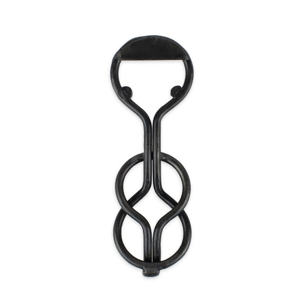 A blackened iron bottle opener with a unique, loop-shaped design.