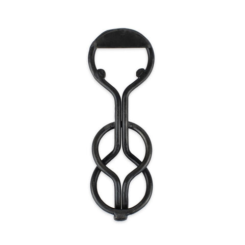 A blackened iron bottle opener with a unique, loop-shaped design.